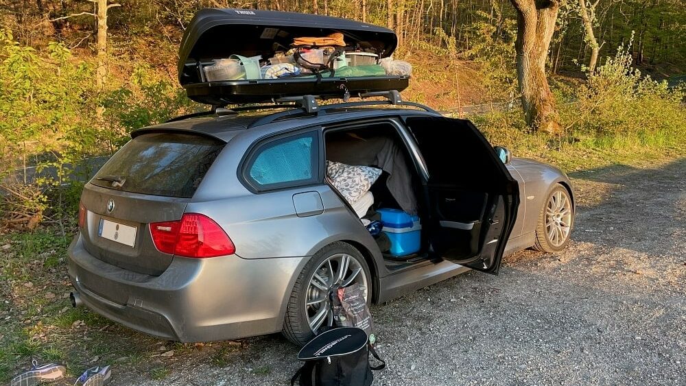 Auto mit geöffnetem kofferraum voller sachen für das camping konzept der  familienzeit im freien im wald modernes europäisches fahrzeug von hinten im  wald